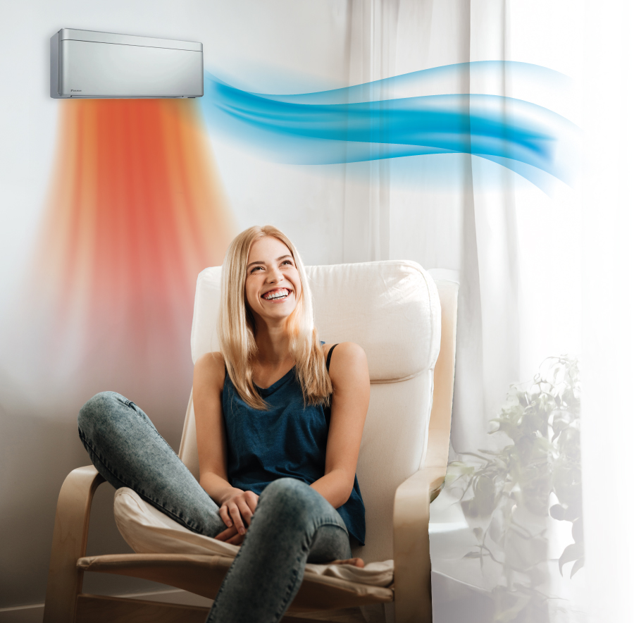 Apollo-Electric Klimaanlage Klimatechnik Wärmepumpe Elektrotechnik | Frau entspannt auf Sessel unter einem Daikin Wandgerät, das warme (orange) und kühle (blaue) Luftströme für ideales Raumklima visualisiert.